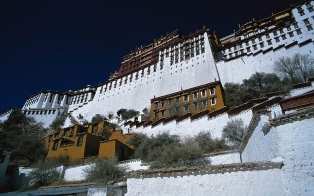 The Potala Palace stands majestically on the hill under a deep blue sky with clear detailed architecture