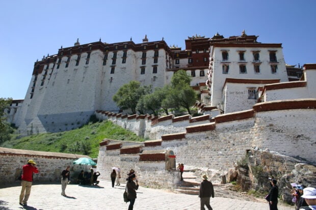 Tourists visiting the ancient Potala Palace on a clear sunny day