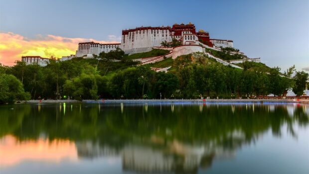 Potala Palace reflecting in a lake with a colorful sunset sky