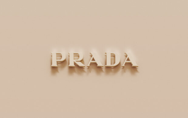 Beige textured surface with raised Prada logo casting soft shadows