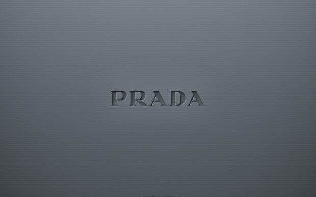Embossed Prada logo on a textured dark gray background with a modern style