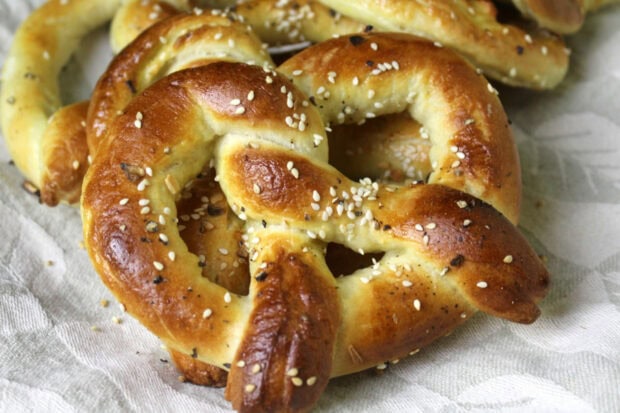 Close up of fresh baked pretzel sprinkled with sesame seeds on cloth