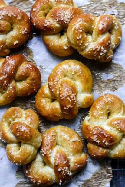 Freshly baked pretzel bread sprinkled with coarse salt on parchment paper