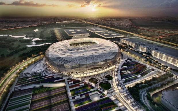 Modern stadium in Qatar surrounded by greenery and urban landscape at sunset