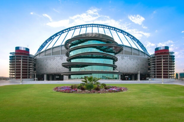 Modern building with circular glass structure in Qatar cityscape