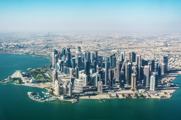 A panoramic view of Doha cityscape with modern skyscrapers and coastline in Qatar