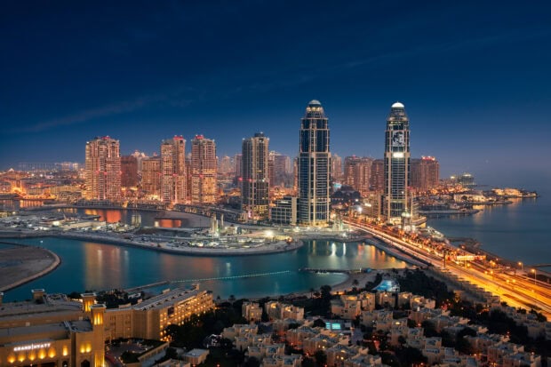 Night view of Qatar cityscape featuring modern skyscrapers and waterfronts in clear skies