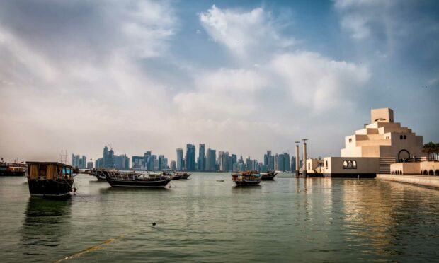 Traditional boats and modern skyline in Qatar cityscape