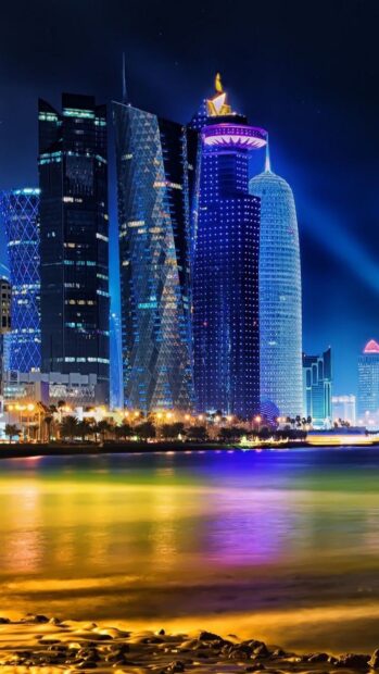 Modern Qatar skyline with vibrant night lights reflecting on water