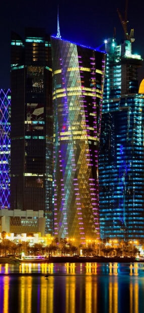 Modern architecture in Qatar lit up with colorful lights at night