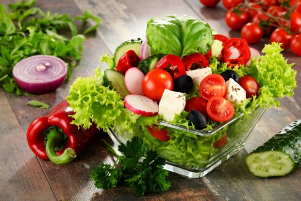 Fresh radish slices arranged in a colorful vegetable salad with lettuce and cherry tomatoes