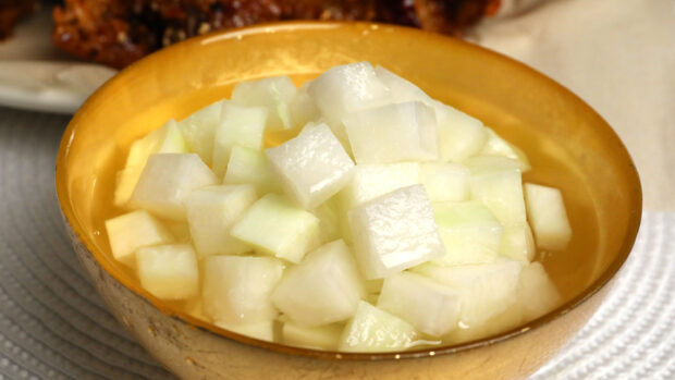 Fresh radish cubes soaked in water inside a golden bowl