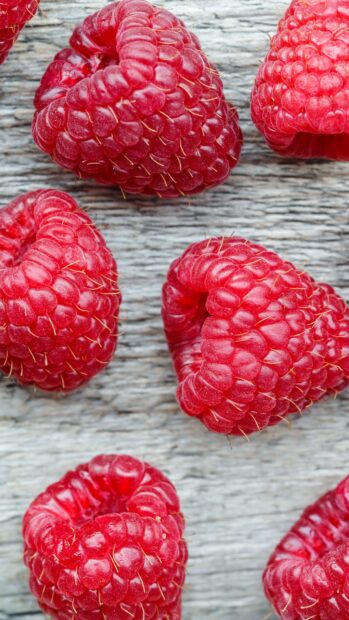 Close up view of fresh raspberry on wooden surface