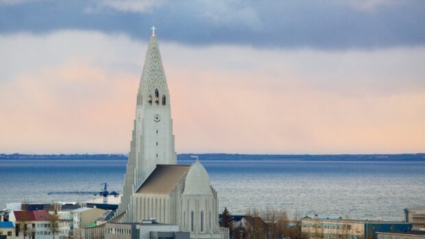 The Reykjavik church stands prominently against the sea and cloudy sky in Reykjavik