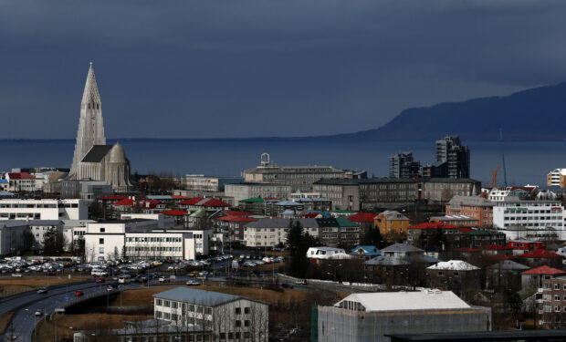 View of Reykjavik cityscape with the iconic church and surrounding buildings under a dark sky