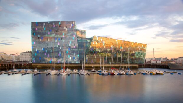 Modern architecture in Reykjavik with boats docked by the waterfront at sunset