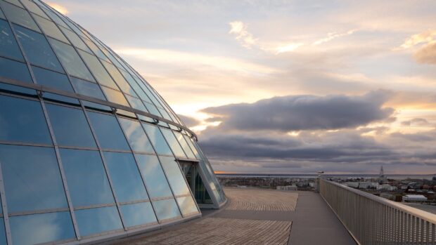 Modern architecture reflecting clouds in Reykjavik cityscape at sunset