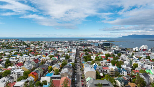 A panoramic view of Reykjavik cityscape with colorful houses and ocean in the distance