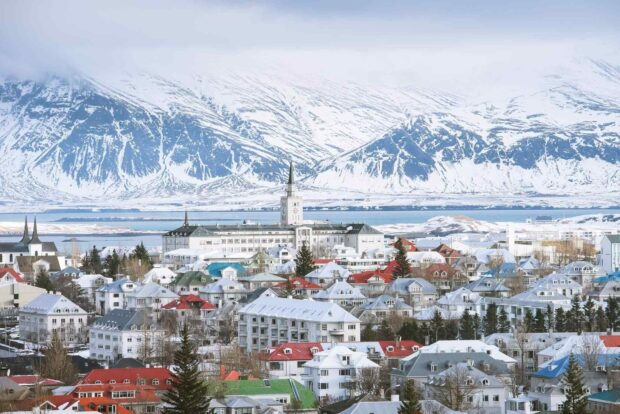 Scenic view of Reykjavik with snowy mountains and colorful rooftops in Iceland