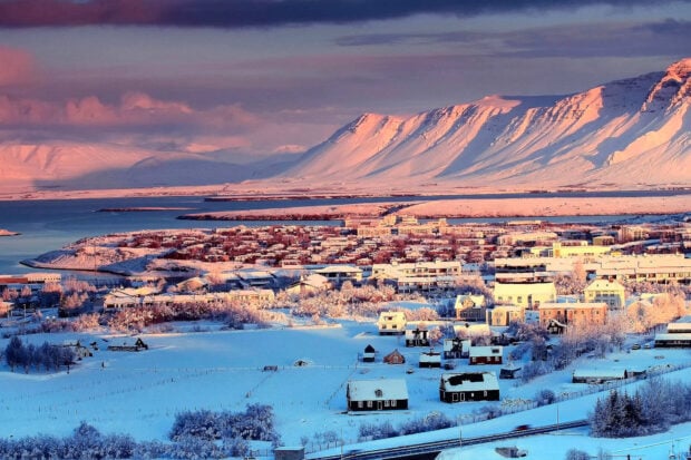Snow covered Reykjavik town with mountain views at sunset