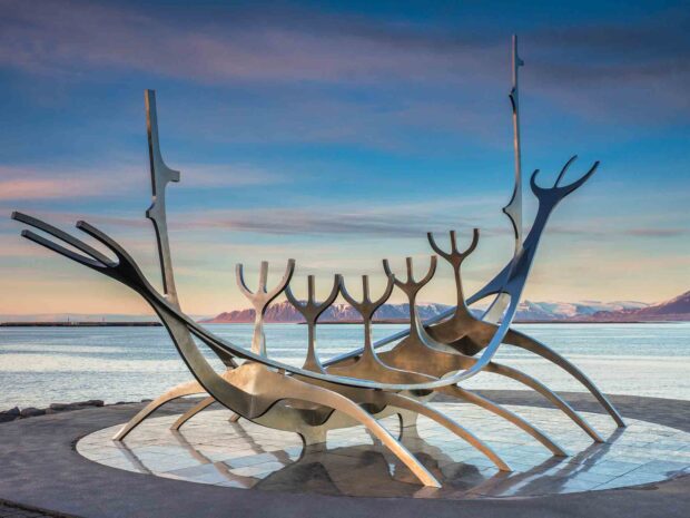 The Sun Voyager sculpture is a modern landmark in Reykjavik showcasing sleek Viking ship outlines against a serene sea and mountain backdrop
