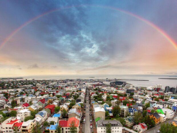 Colorful Reykjavik cityscape with a rainbow arching over the citywide view