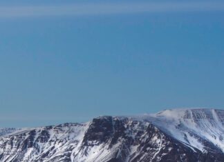 Snow covered Reykjavik cityscape with mountains in the background during twilight