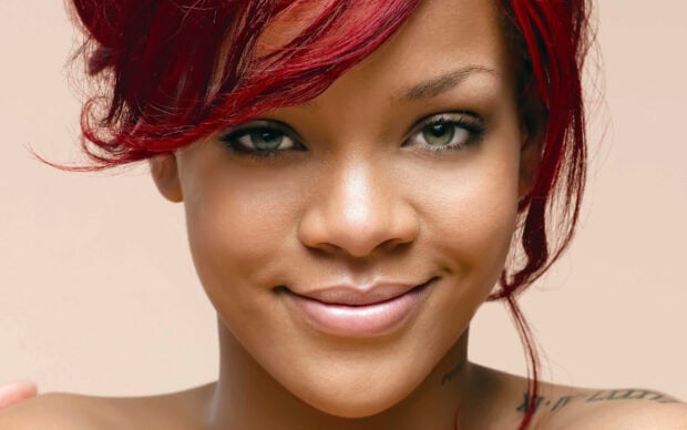 Rihanna close up showing confident expression with red hair