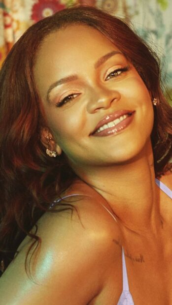 Close up of Rihanna smiling with natural makeup and wavy hair
