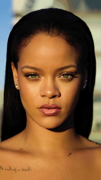 Close up of Rihanna with green eyes and natural makeup on her face