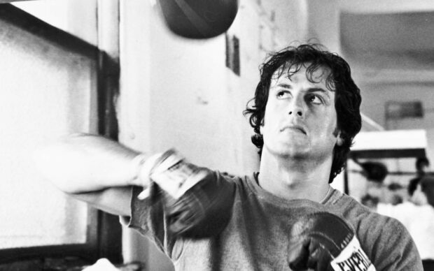 Rocky wearing boxing gloves training inside the gym