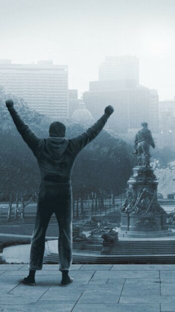 Rocky standing with raised arms overlooking cityscape and monument in high quality