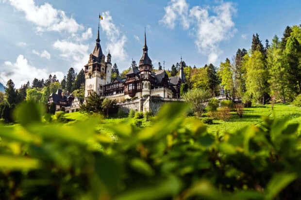 Historic Romanian architecture on a hill surrounded by lush greenery in Romania