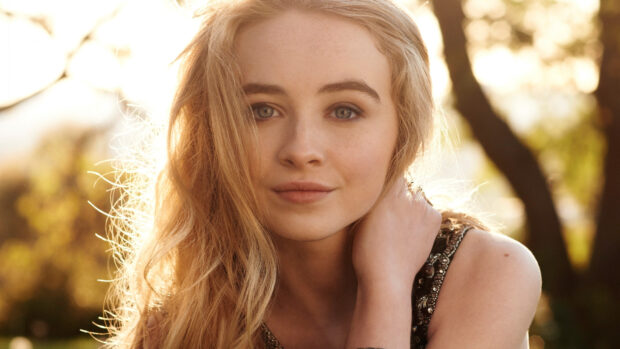 Sabrina Carpenter posing outdoors with natural light highlighting her blonde hair and blue eyes