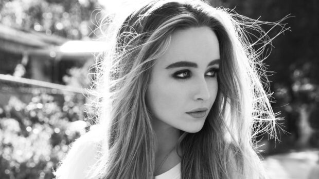 Sabrina Carpenter looking thoughtfully to the side with her hair blowing in the wind in a high resolution portrait