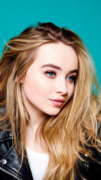 Sabrina Carpenter with long blonde hair against a blue background