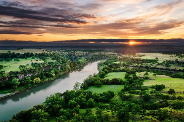 Scenic river flowing through green Sacramento landscape at sunset