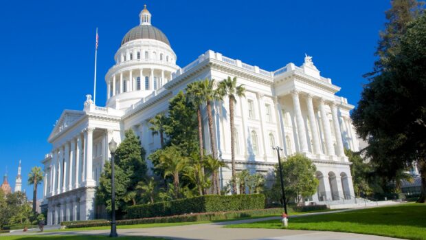 The Capitol building in Sacramento with clear blue sky and surrounding palm trees