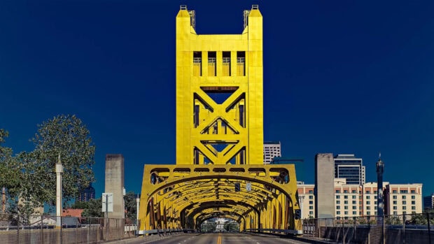 The iconic Sacramento tower in a bright yellow structure against a clear blue sky