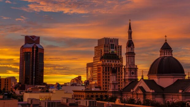 Historic Sacramento skyline with church towers under a vibrant sunset sky