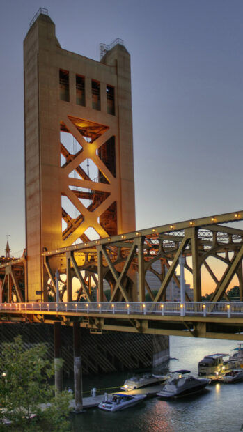 Sacramento tower bridge with boats docked on the river at sunset