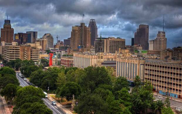 View of San Antonio Texas cityscape with tall buildings and greenery under cloudy sky