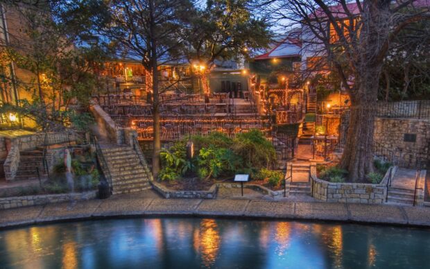A peaceful outdoor dining area in San Antonio Texas with lights and trees near the riverwalk