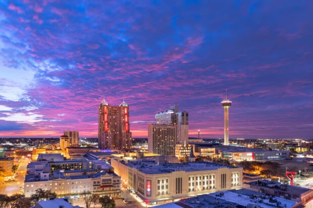 San Antonio Texas cityscape under a vibrant purple and pink sunset sky