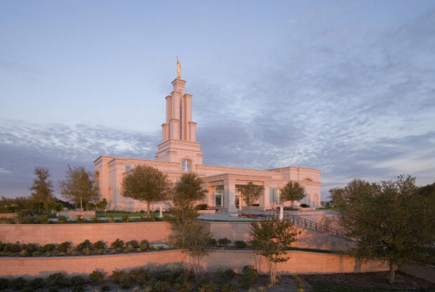 The San Antonio Texas temple with surrounding trees under a cloudy sky