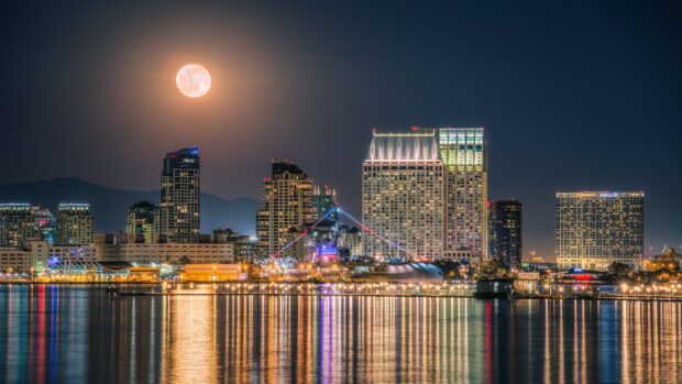 Night view of San Diego cityscape with full moon over California