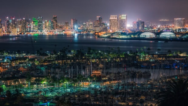 Night view of San Diego California with illuminated city skyline and marina boats