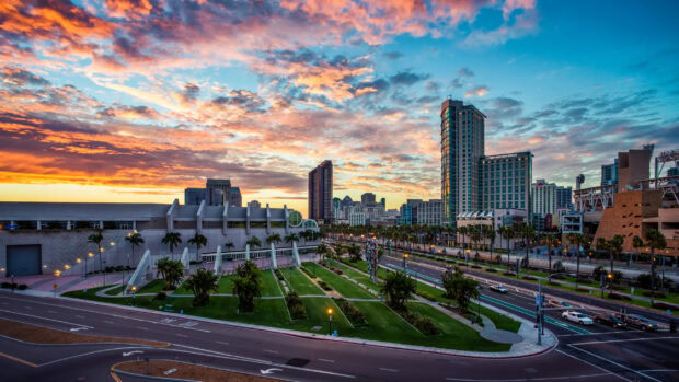 A vibrant cityscape of San Diego California with modern buildings and a colorful sunset sky