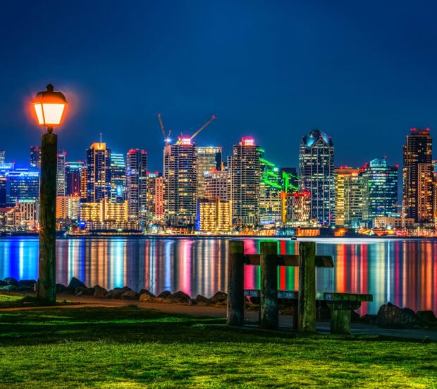 Nighttime view of San Diego cityscape with illuminated buildings and colorful reflections