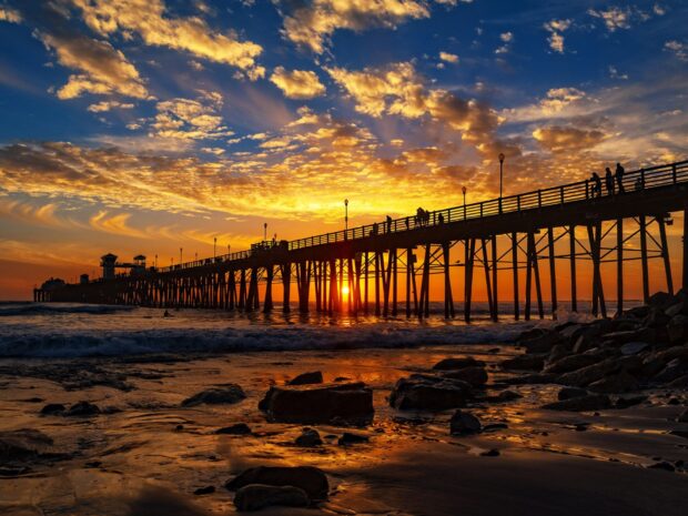 Sunset over San Diego California pier with vibrant clouds and ocean waves